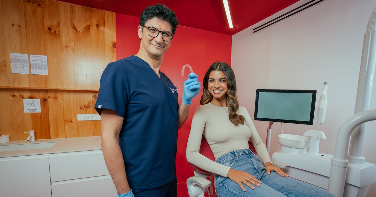 Tandarts met een onzichtbare beugel in zijn hand met patient in de stoel