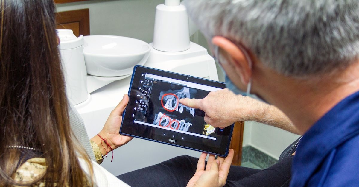 Un dentiste montre sur un scanner dentaire comment les dents d'un patient se sont déplacées.