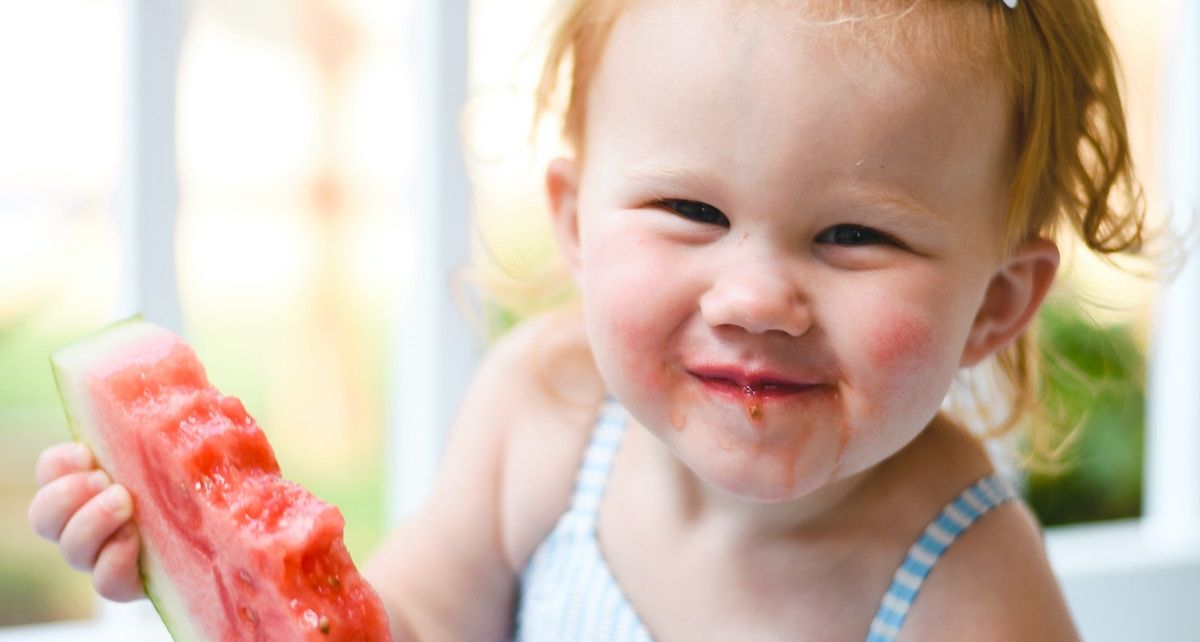 Baby isst ein Stück Wassermelone.