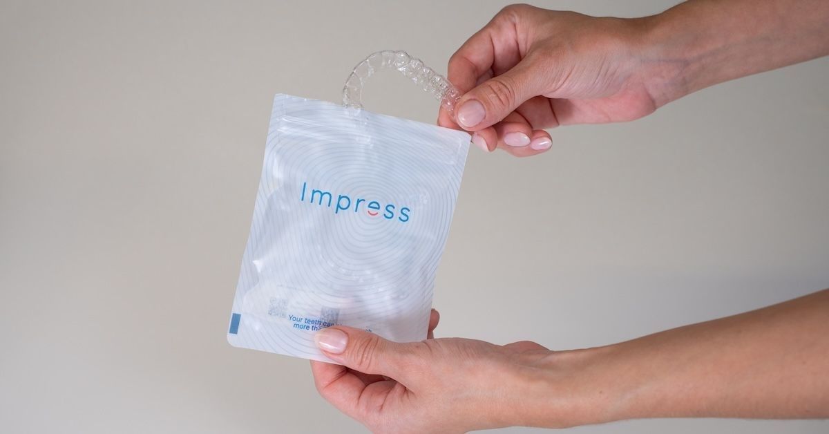 Uma mulher retira o alinhador do saquinho da Impress