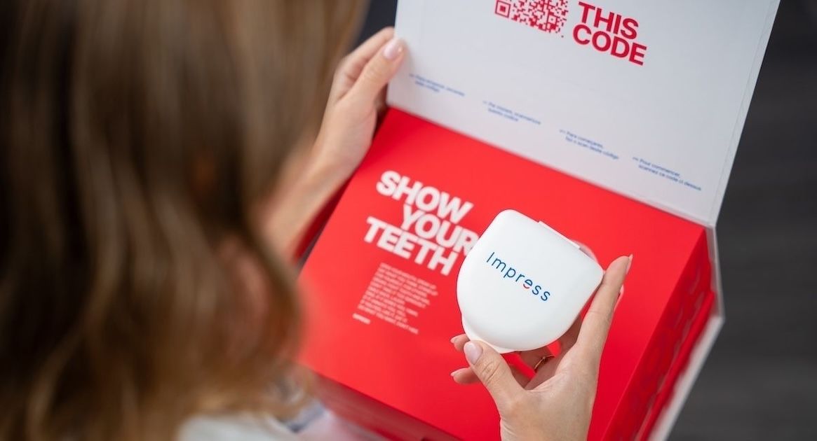 Vrouw die een doos met Impress-aligners vasthoudt.