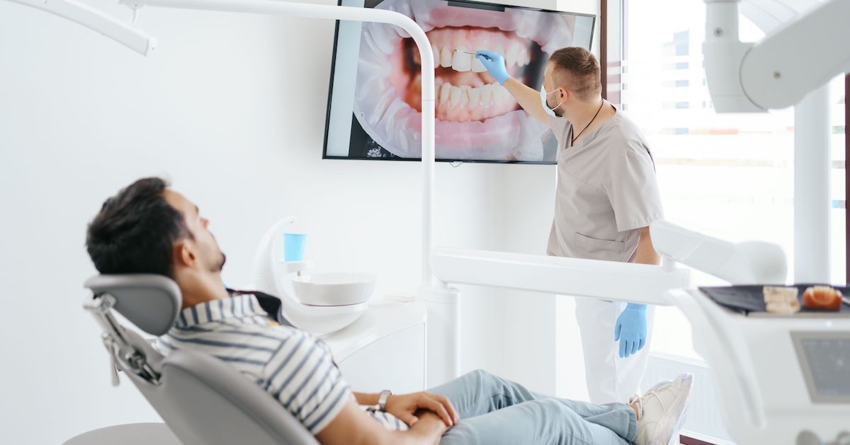 de tandarts laat aan patient zien waar hij trekkend tandvlees heeft