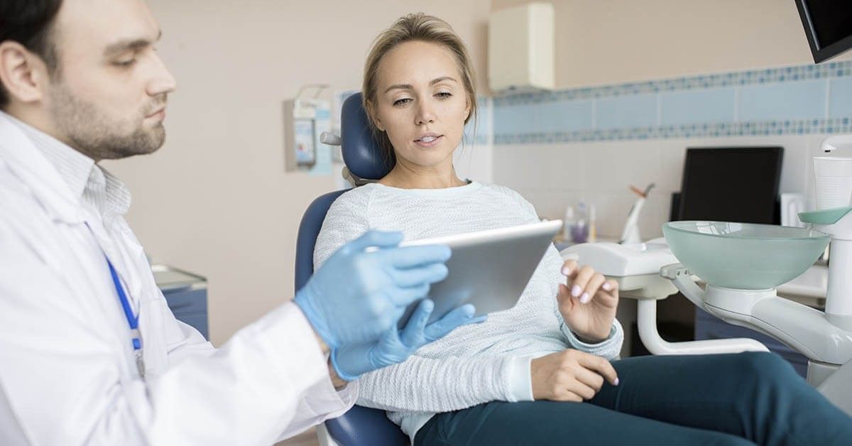 Een orthodontist en zijn patiënt bespreken de behandeling.&nbsp;