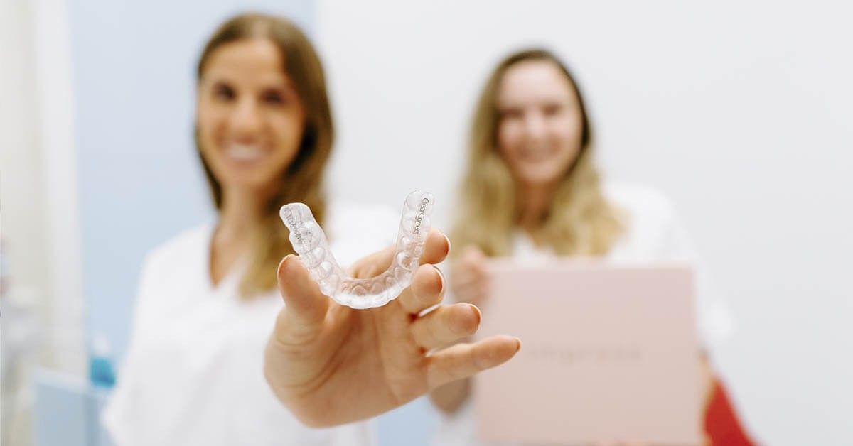 Impress tandarts die een doorzichtige beugel laat zien