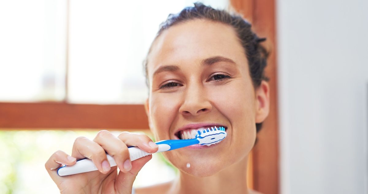 Een vrouw die trots haar tanden poets