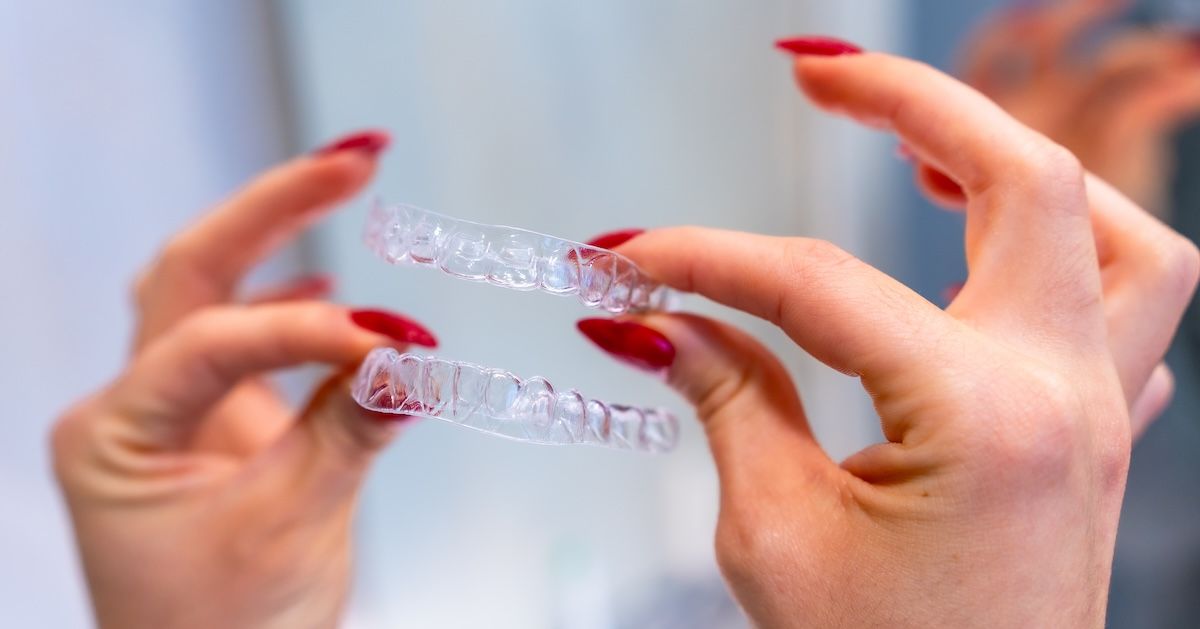 Een vrouw die aligners vasthoudt
