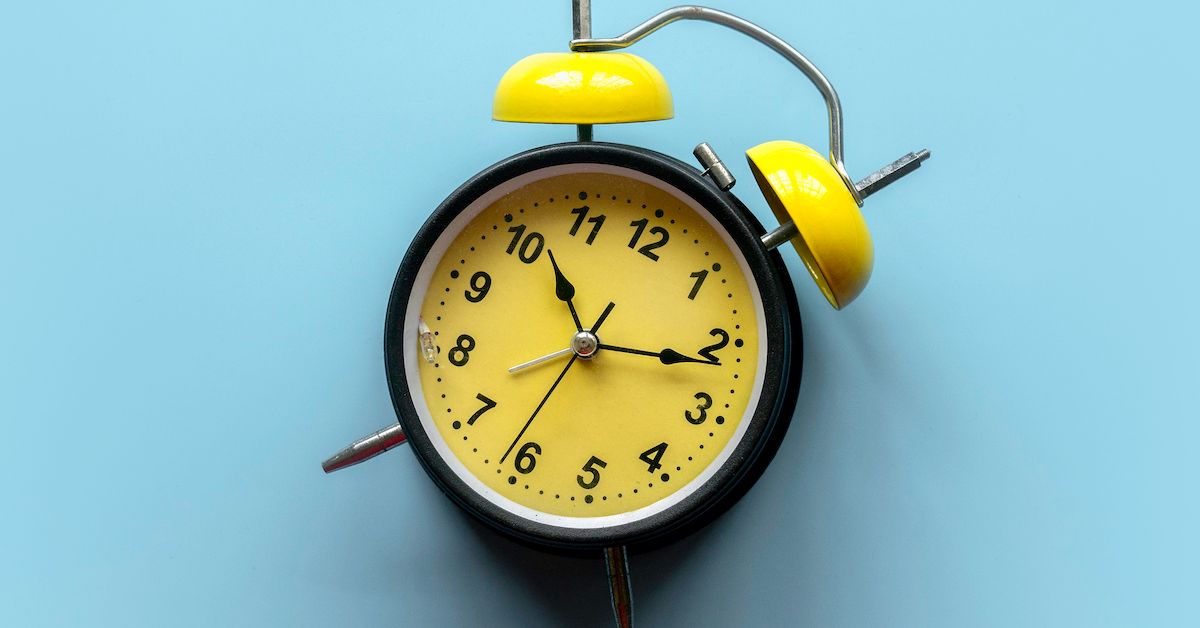 Reloj negro y amarillo sobre fondo azul que hace referencia al tiempo que dura la ortodoncia.