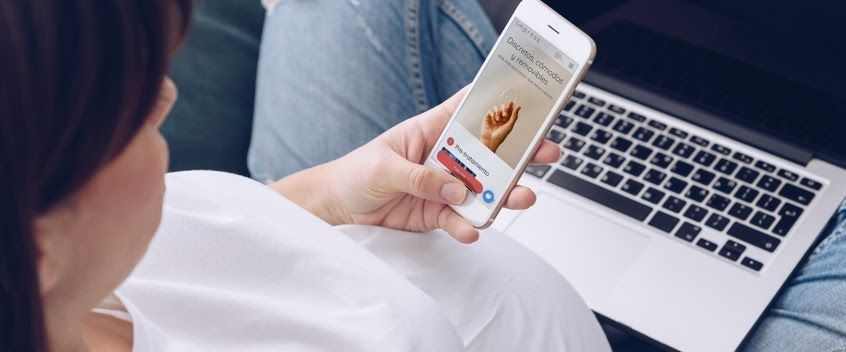 Een zwangere patiënte bekijkt de tandheelkundige app tijdens een tandheelkundige behandeling. 