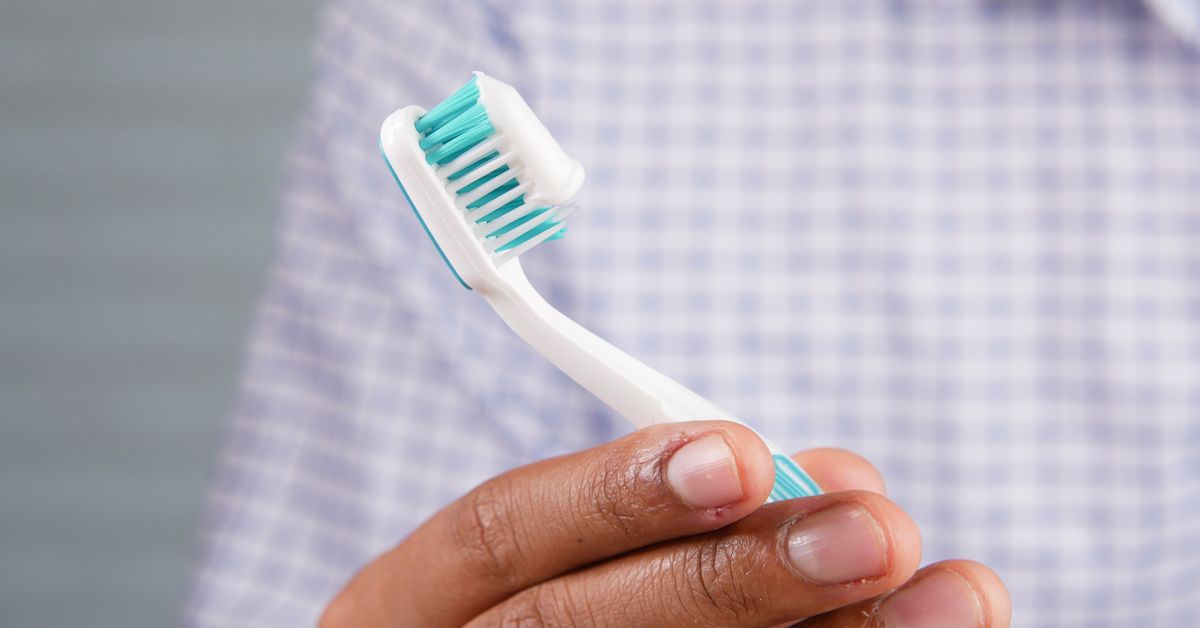 Person holiding a toothbrush with toothpaste