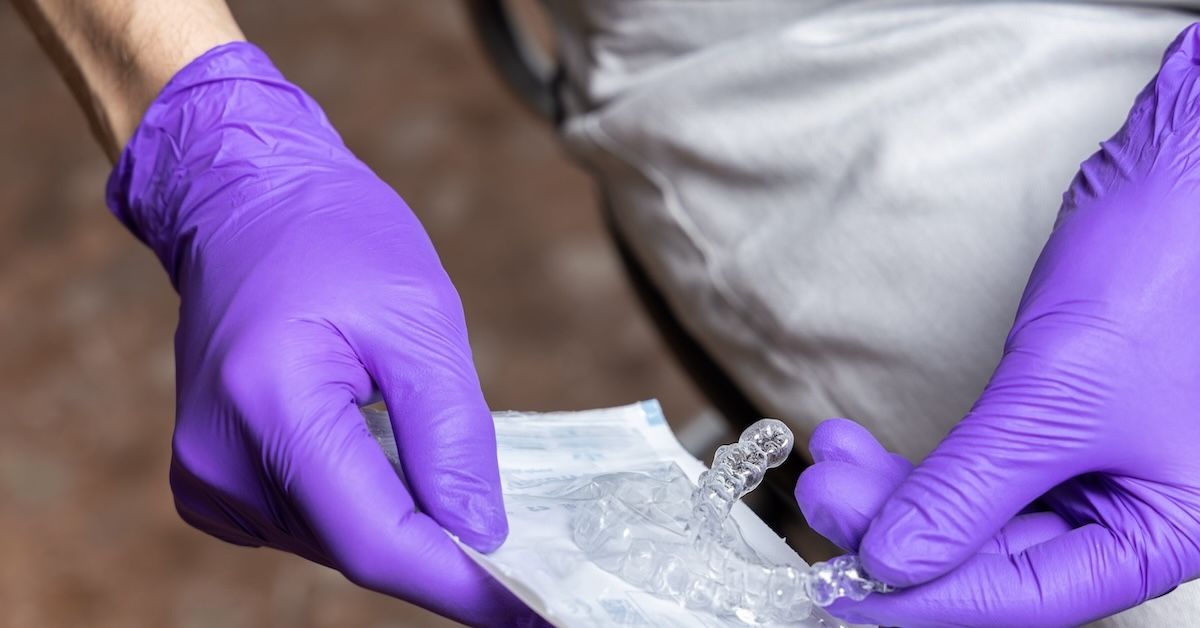 Dentist holding aligners in their gloved hands
