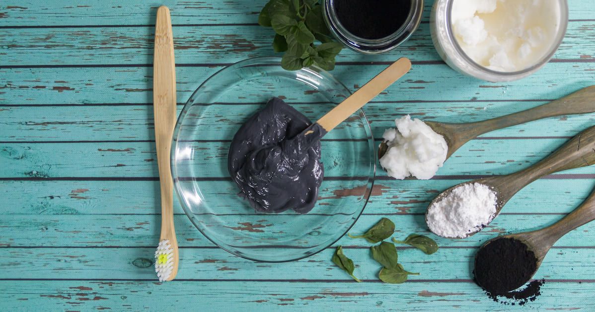 Un bodegón con diferentes productos naturales como carbón activo, bicarbonato y cepillos de dientes de madera.&nbsp;