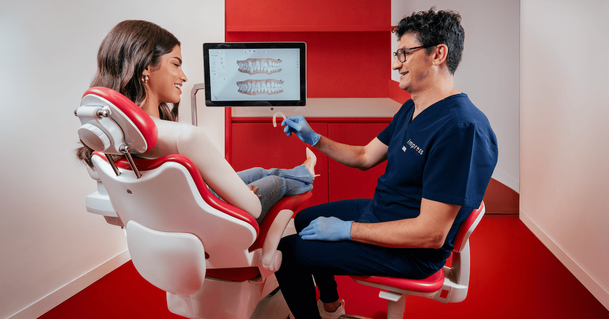 Zahnarzt zeigt einer Patientin die transparenten Zahnschienen