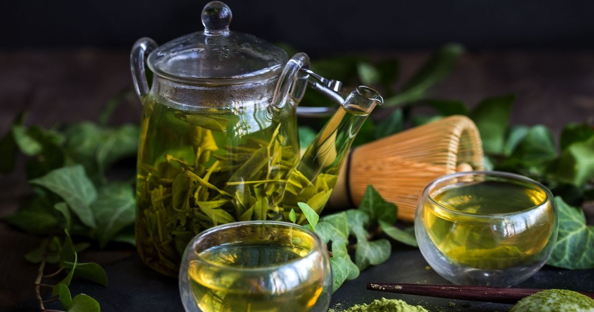 thee pot met twee kopjes waar groene thee in zit