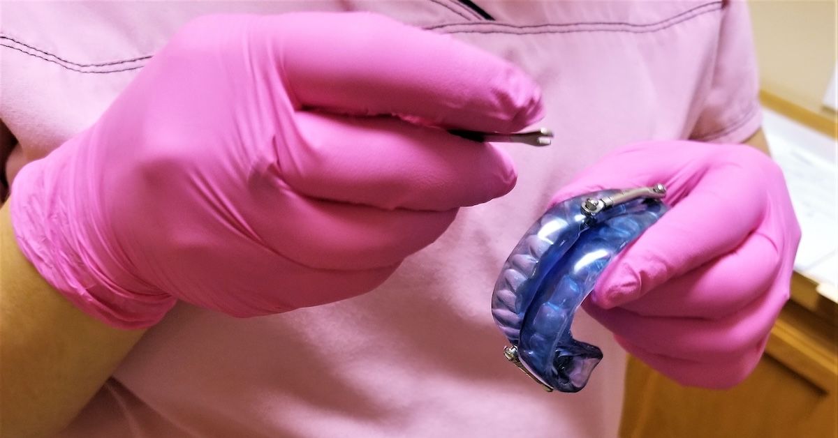 Dental technician modifying retainers
