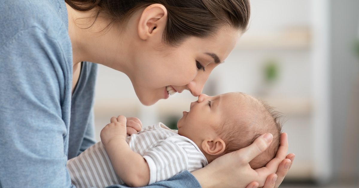 Een moeder die lacht naar haar baby