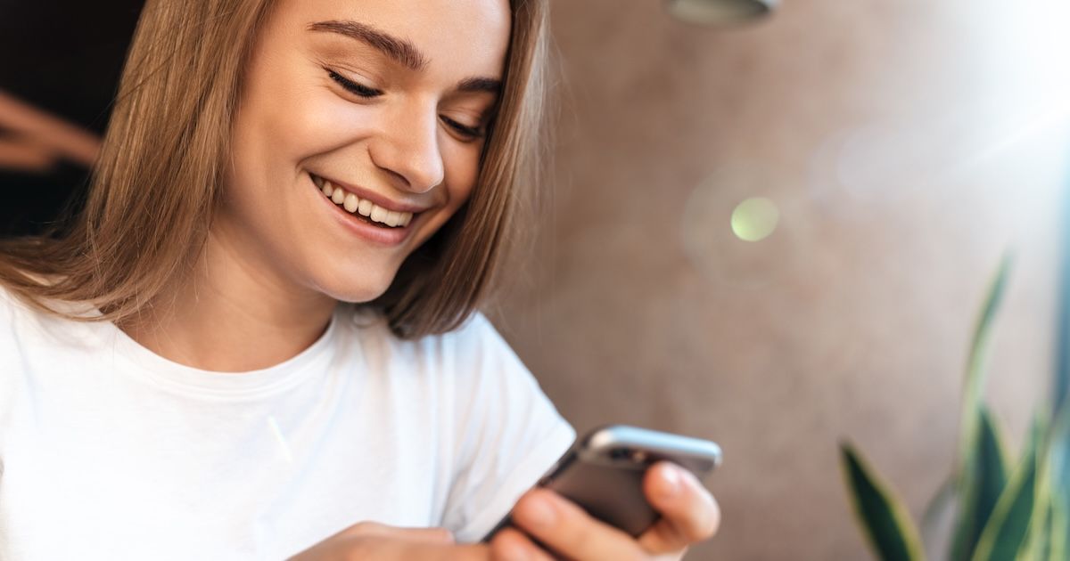 Een vrouw die kijkt op haar telefoon naar haar Impress app