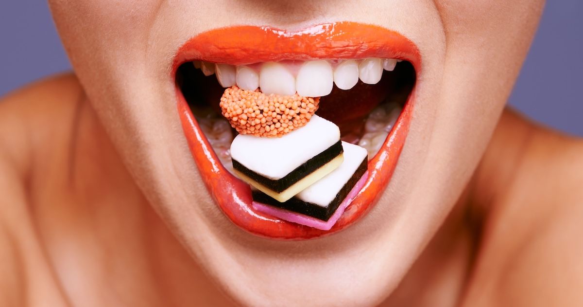 Een mond met engelse drop tussen haar tanden