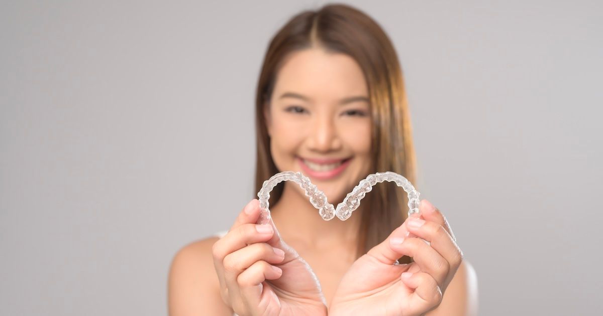 Een lachende de vrouw die onzichtbare beugels vasthoudt