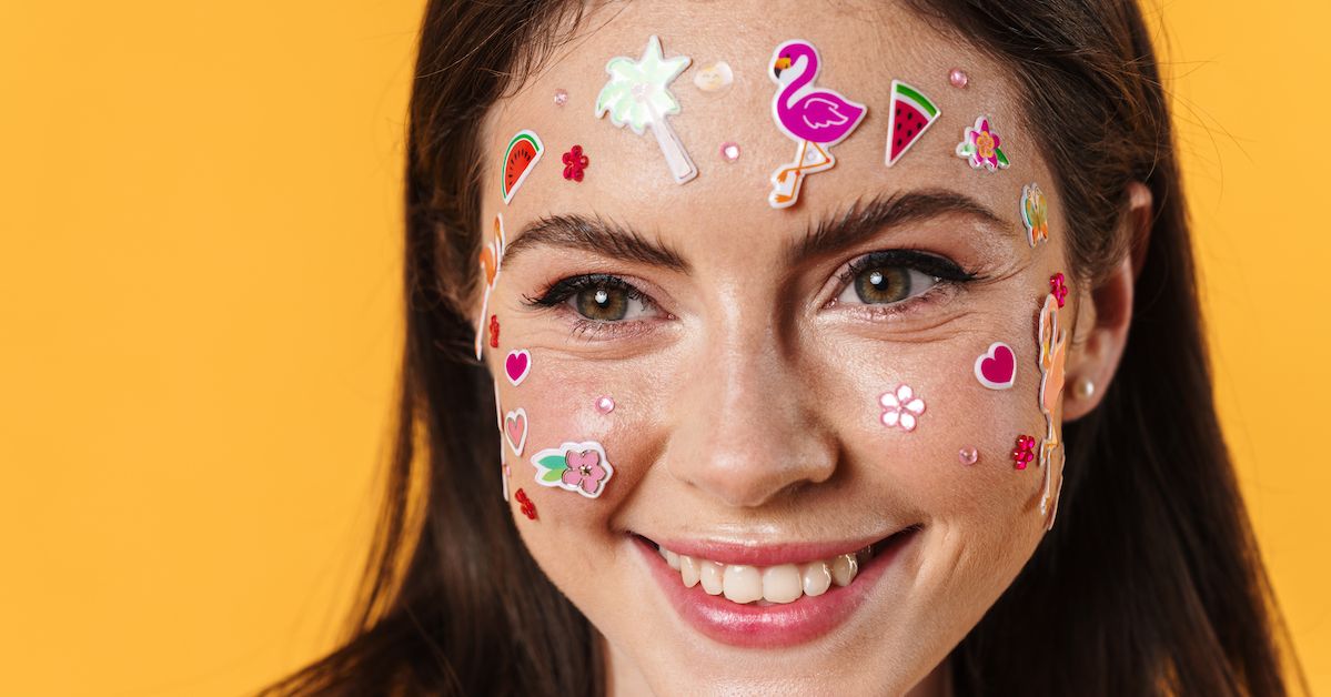 Una chica tiene muchas pegatinas en la cara que representan los stickers que se ponen en los granos de la boca.