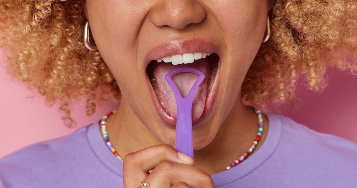 een vrouw die haar tong aan het reinigen is met een tongschraper