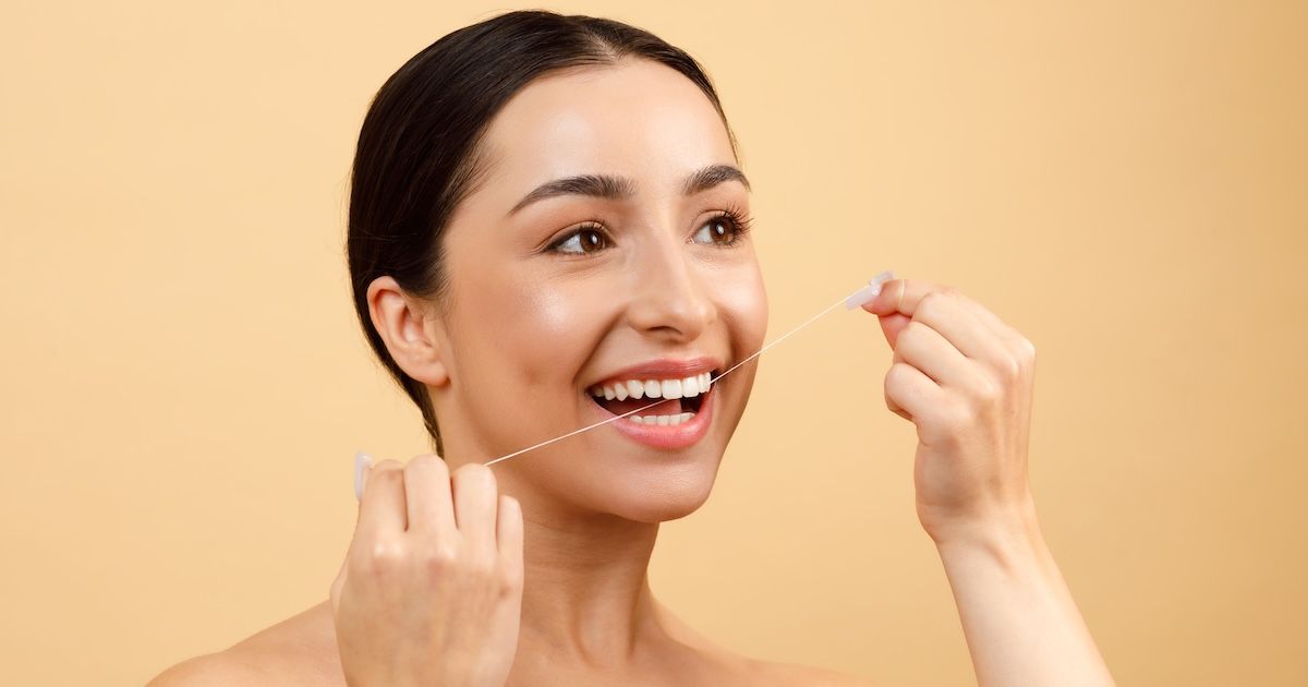 een vrouw die elke dag haar tanden flosst