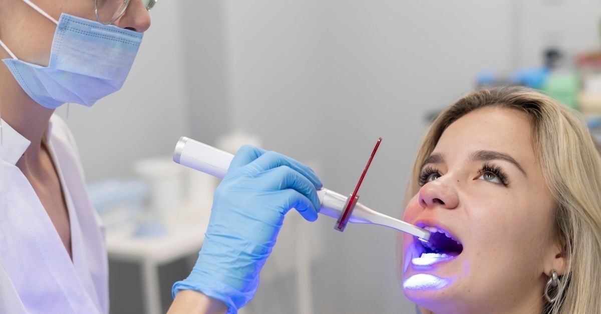 Tandarts die de tanden behandelt tijdens het bleekproces.