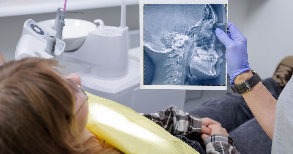tandarts die een röntgenfoto van de mond omhooghoudt voor de patiënt