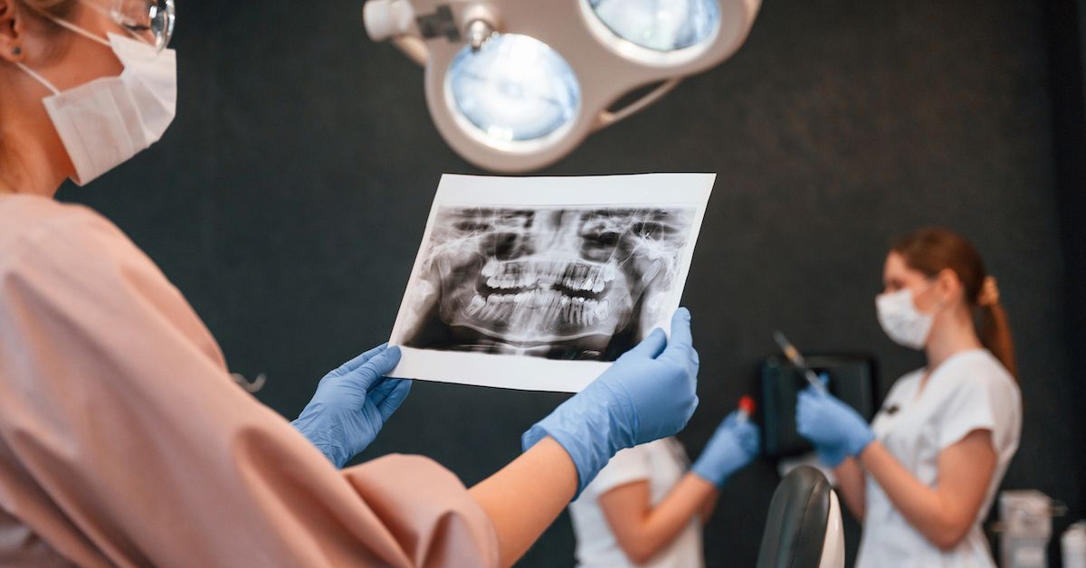 A dentist holding a patient's scan to review the health of the teeth