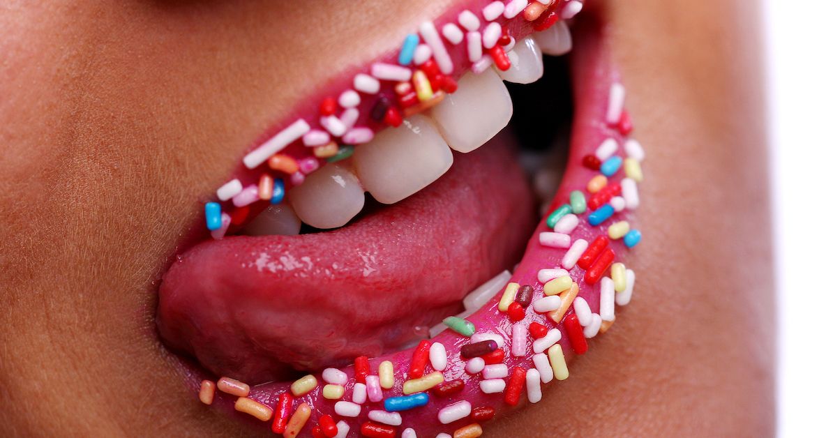 A woman licking icing sprinkles off her lips