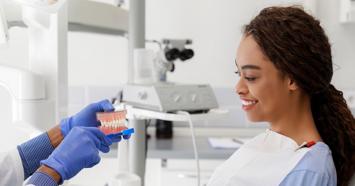 en vrouw zit bij de orthodontist te kijken naar een gebit