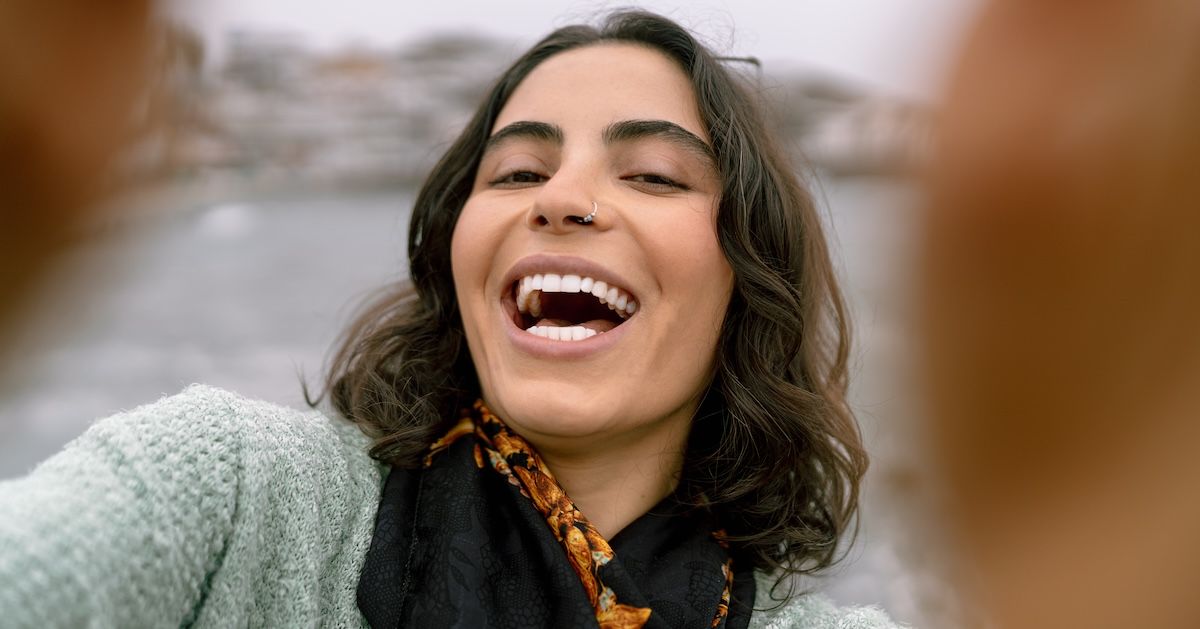 Een blije vrouw die een selfie maakt op het strand